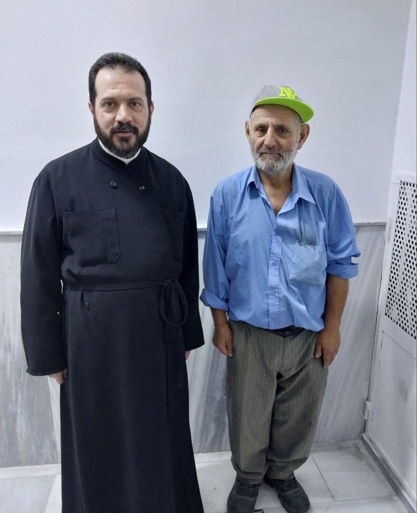 Le père Basilios avec un bénéficiaire âgé de la cuisine caritative